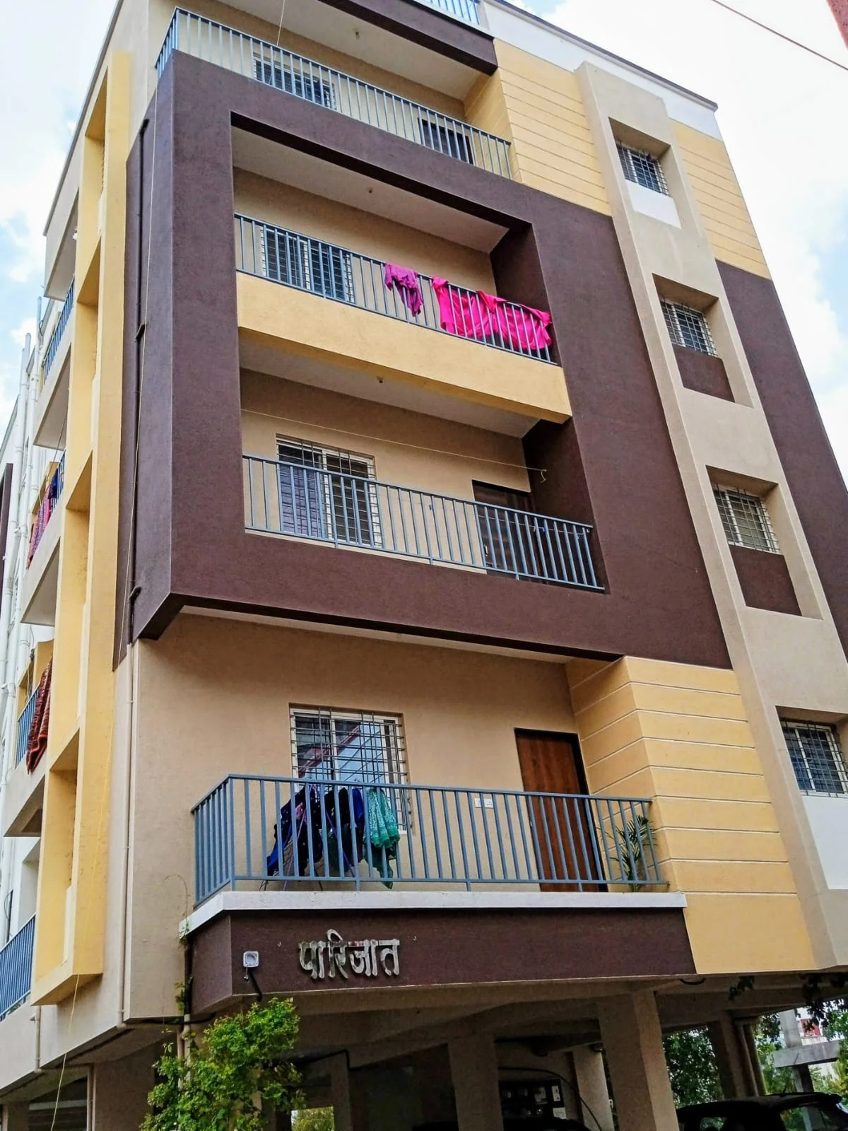 Front view of Parijat PG accommodation in Hadapsar Pune showing building entrance and parking space